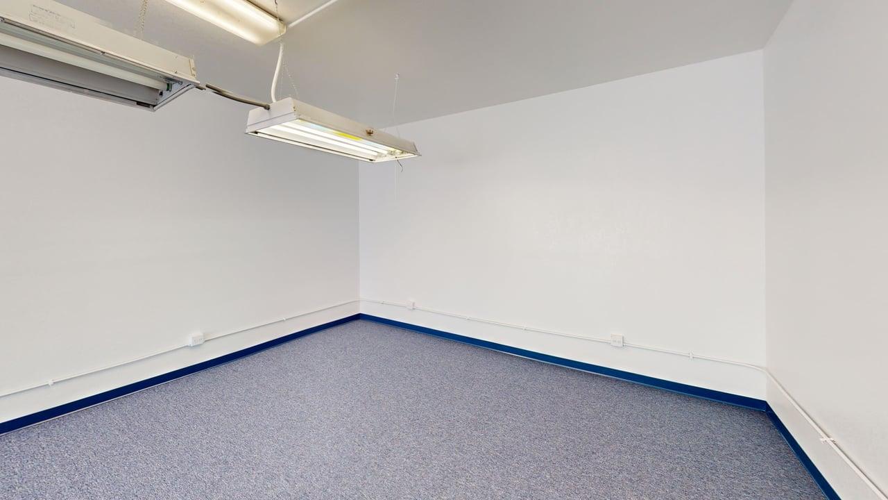 Carpeted room with overhead lighting, suitable for meetings
